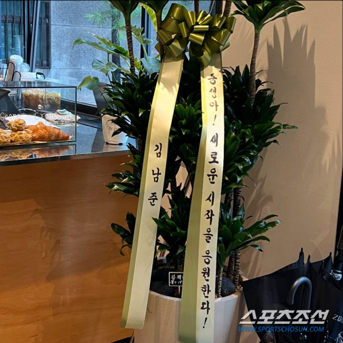 The iconic congratulatory plant sent by BTS leader RM to his sister's cafe opening, featuring the famous personalized ribbon.