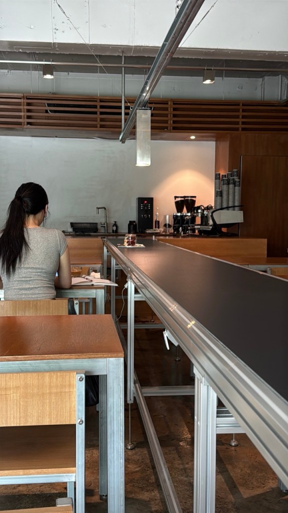 A premium hand-drip coffee and designer butter cake being served via the innovative automated conveyor belt system.