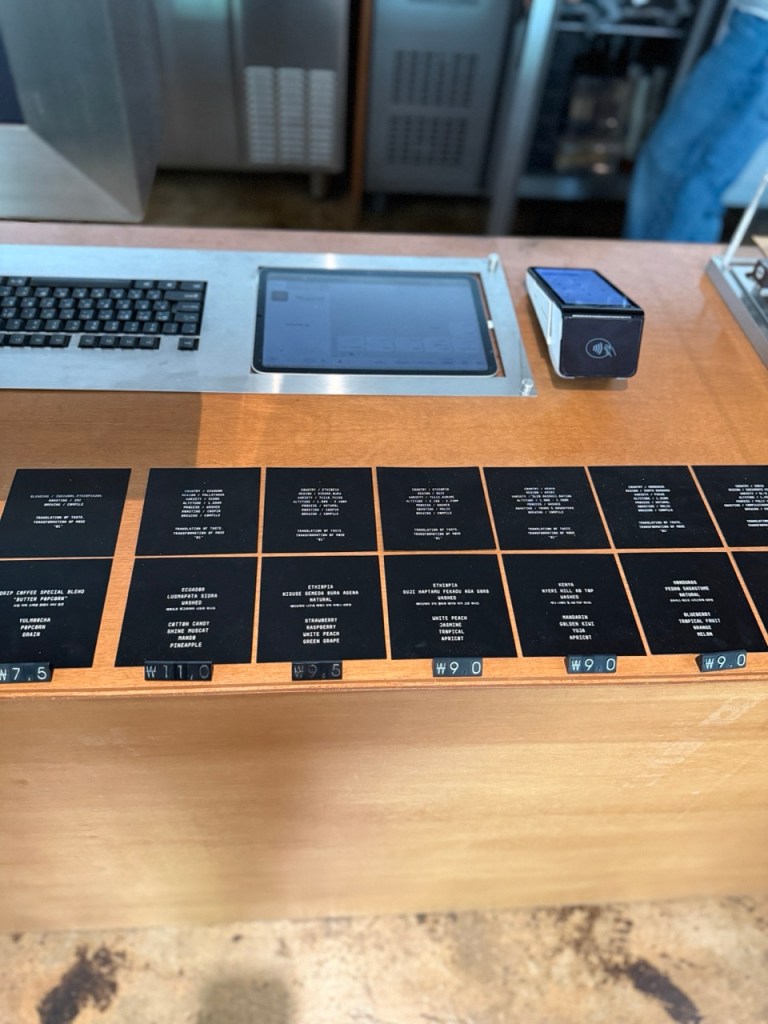 A detailed focus on the curated filter coffee menu card showcasing diverse single-origin flavor profiles at Compile cafe.