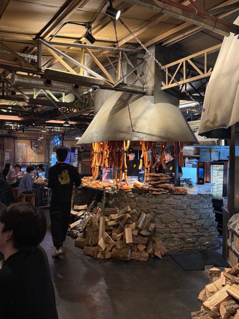 The atmospheric, moody, and lively interior seating layout of Dalmai Square BBQ, packed with trendy local youth.