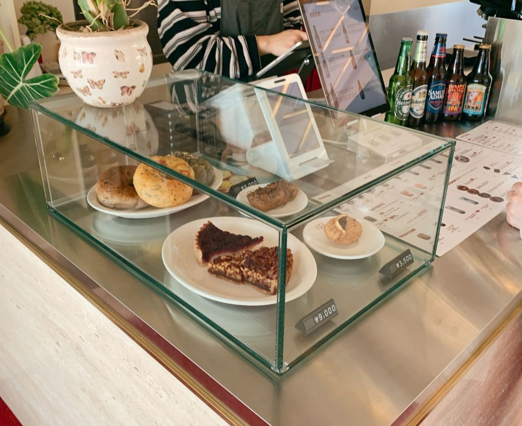 A sleek, minimalist transparent dessert case displaying curated artisan pastries and gelato components at Green Room.