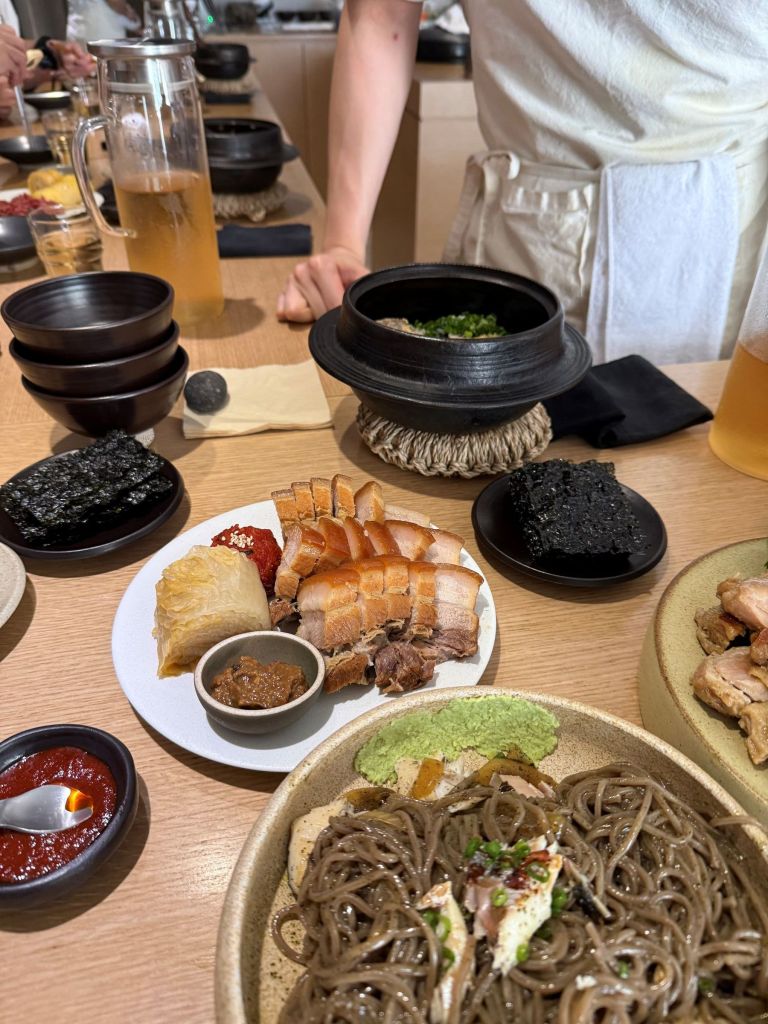 A beautifully arranged gourmet table setting of premium bossam, perilla oil makguksu, and cutlassfish pot rice at Seonchae Seongsu.
