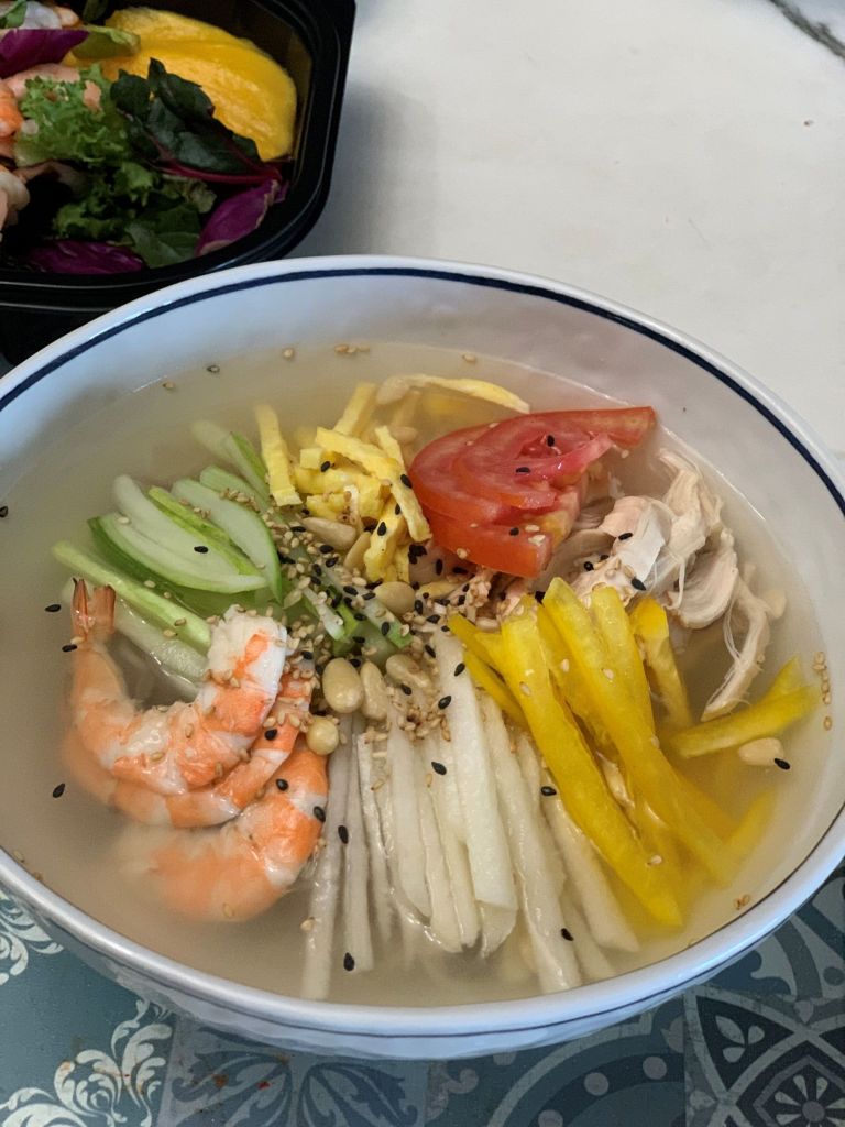 A refreshing aesthetic bowl of Chokyetang, traditional Korean chilled tangy chicken soup served with crushed ice and sliced cucumbers.