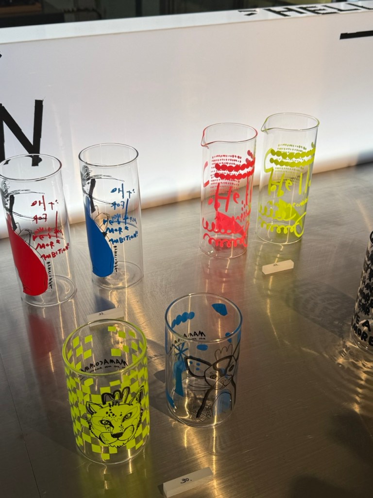 A detailed focus on the carefully arranged designer cups, postcards, and lifestyle products curated for gallery-goers.