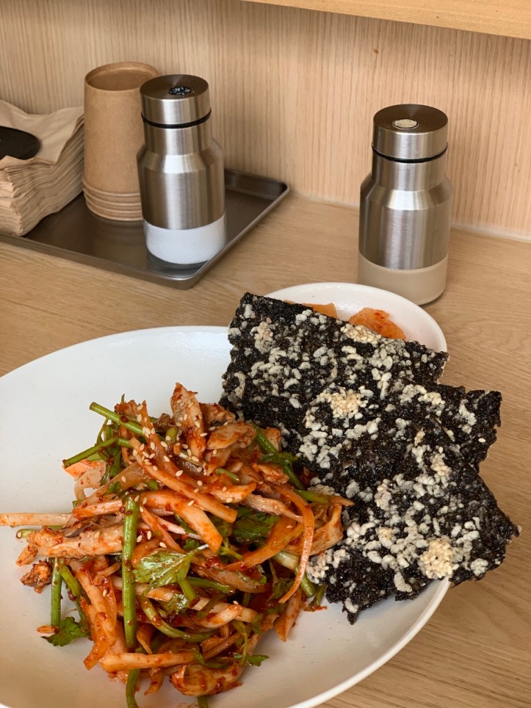 n elegant presentation of Gyewol's signature cold seasoned chicken salad with fresh minari and spicy tangy dressing