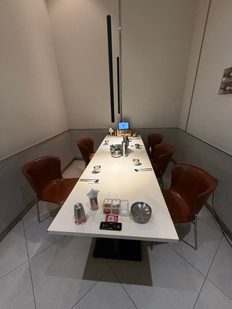 A high-satisfaction focus on the spacious, clean, and contemporary long wooden table inside the private room.