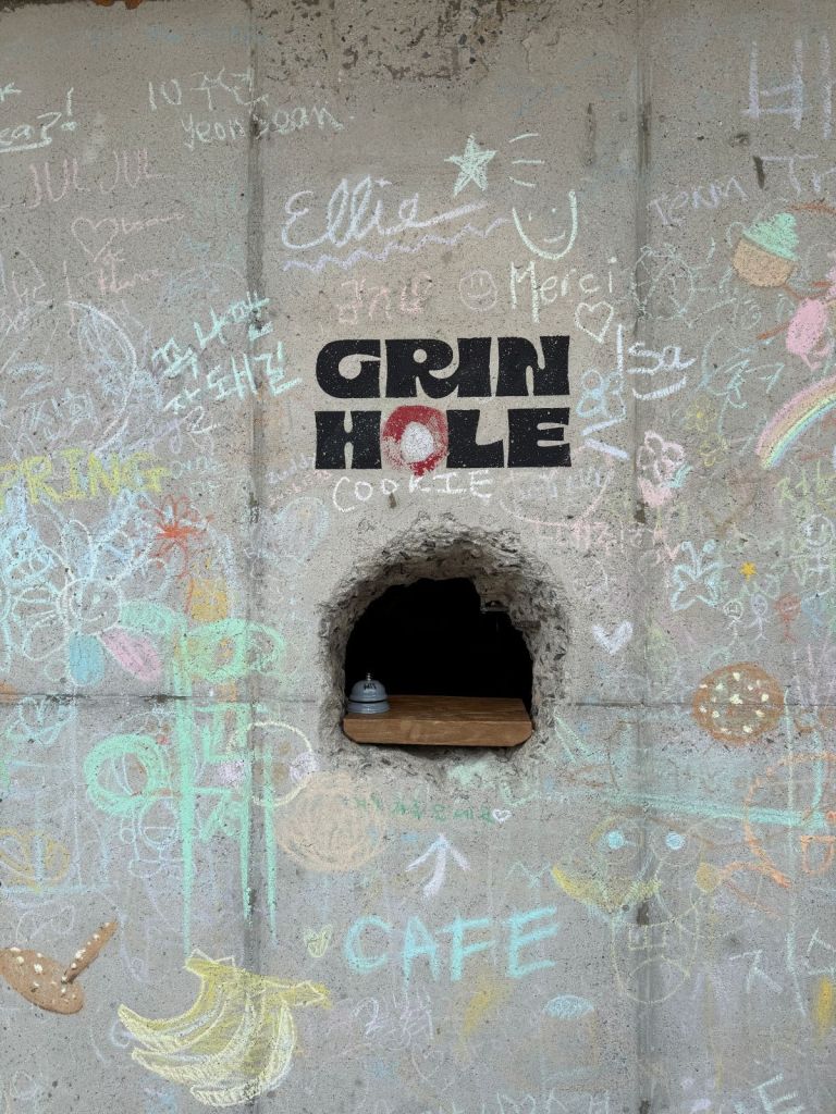 A close-up shot of the unique interactive hole in the wall designed for ordering premium desserts at Green Hole.