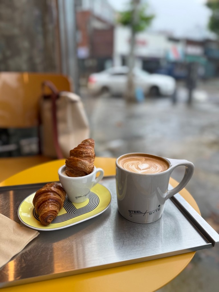 A high-satisfaction top-down view of signature cream latte and desserts served inside Steel Bite cafe in Mullae-dong.