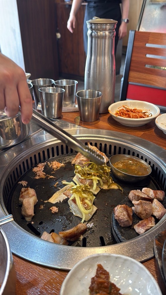A cinematic focus on an expert staff member grilling thick aged pork at the precise temperature for guests.