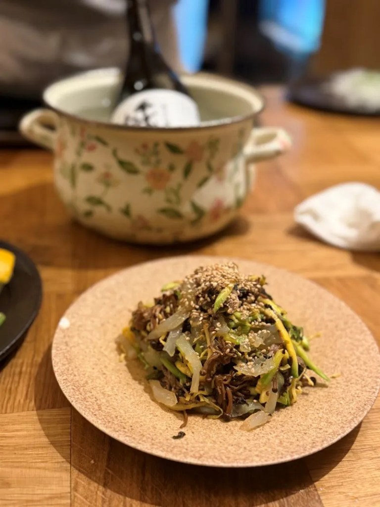A high-satisfaction macro close-up of translucent mung bean jelly strands tossed with sesame oil, beef, and vegetables.