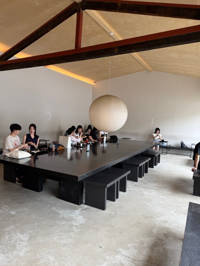 A cinematic focus on the warm wooden bench seating and soft ambient lighting inside Moki cafe.