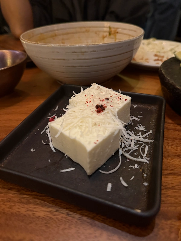 A detailed macro shot capturing a creative Korean tapas appetizer featuring seasonal ingredients.