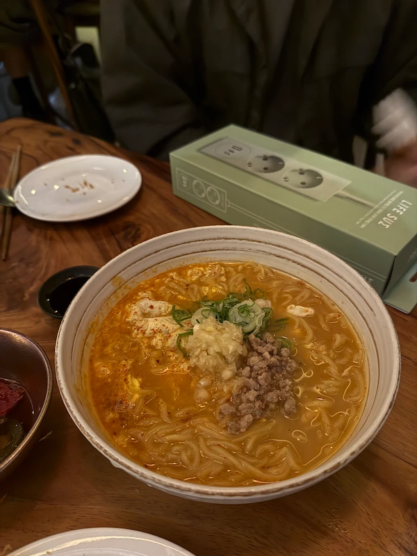 top-down view of a piping hot bowl of spicy egg ramen served as a finale dish at Mukmuki.